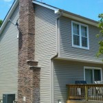 After Pebblestone Clay siding, gutters, and downspouts White soffit, fascia, and window trim