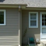 After Pebblestone Clay color siding, gutters, and downspouts White soffit and fascia, and window trim