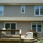 After Pebblestone Clay siding, gutters, and downspouts White soffit, fascia, and window trim